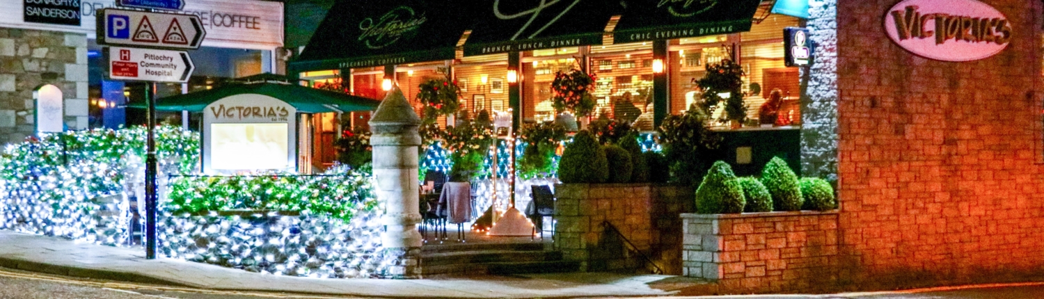 Victoria's Restaurant in Pitlochry shown at night with the outdoor area all lit up